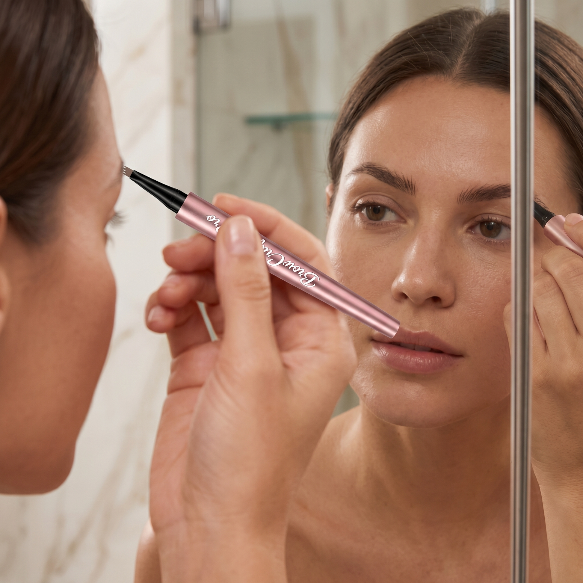 Applying eyebrow pen in mirror for natural defined brows using BrowCraft Pro